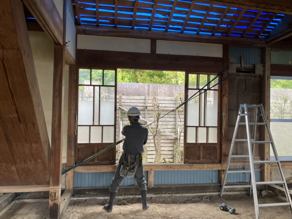 傾いた柱をまっすぐに戻すため、専用の器具で引き寄せながら補強している様子