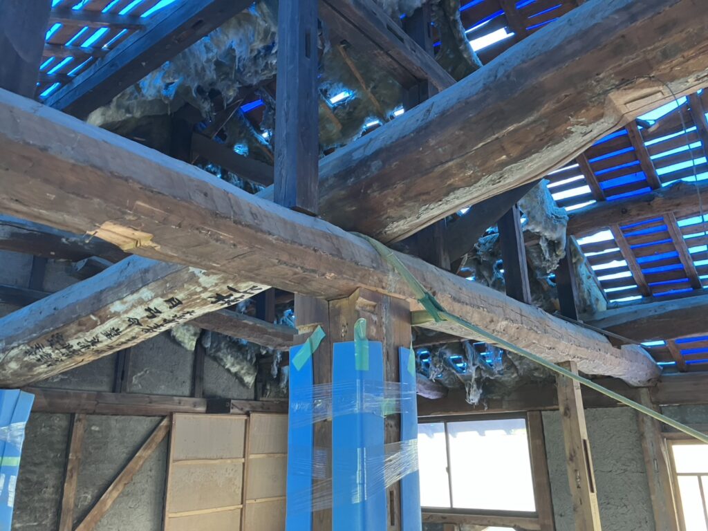 傾いた柱をまっすぐに戻すため、梁と柱を引きながら位置を調整している様子